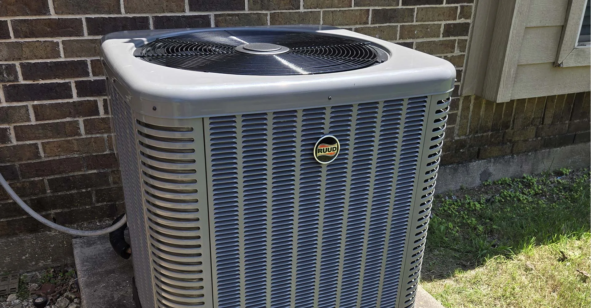 Close-up of a heat pump condenser during a 2L maintenance visit in North Texas