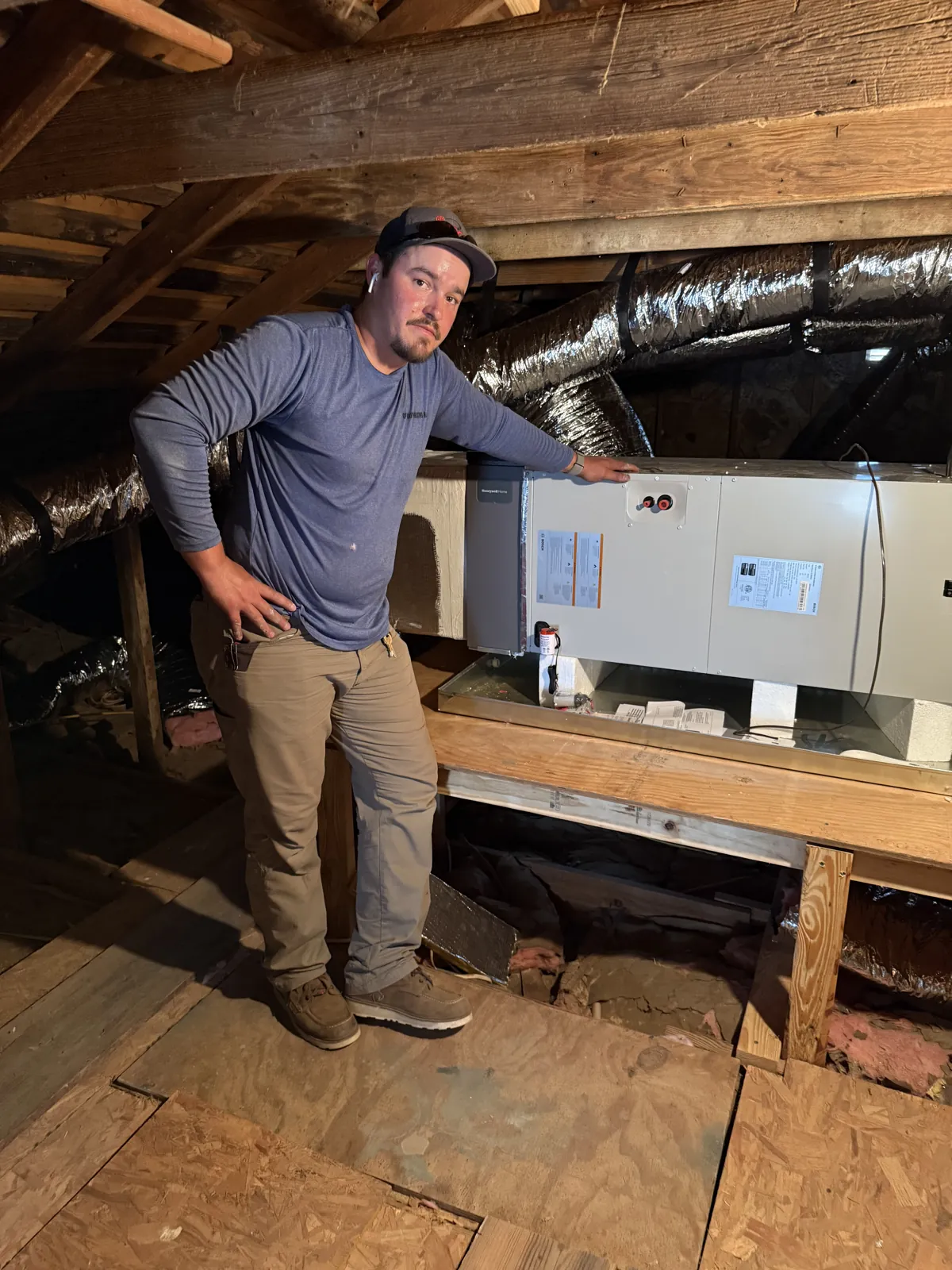 HVAC technician checking an attic air handler during a pre-warranty inspection